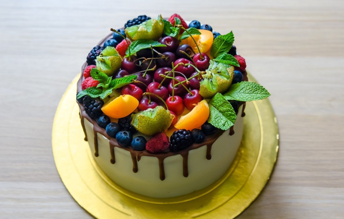 Торт украшенный фруктами и вкусняшками