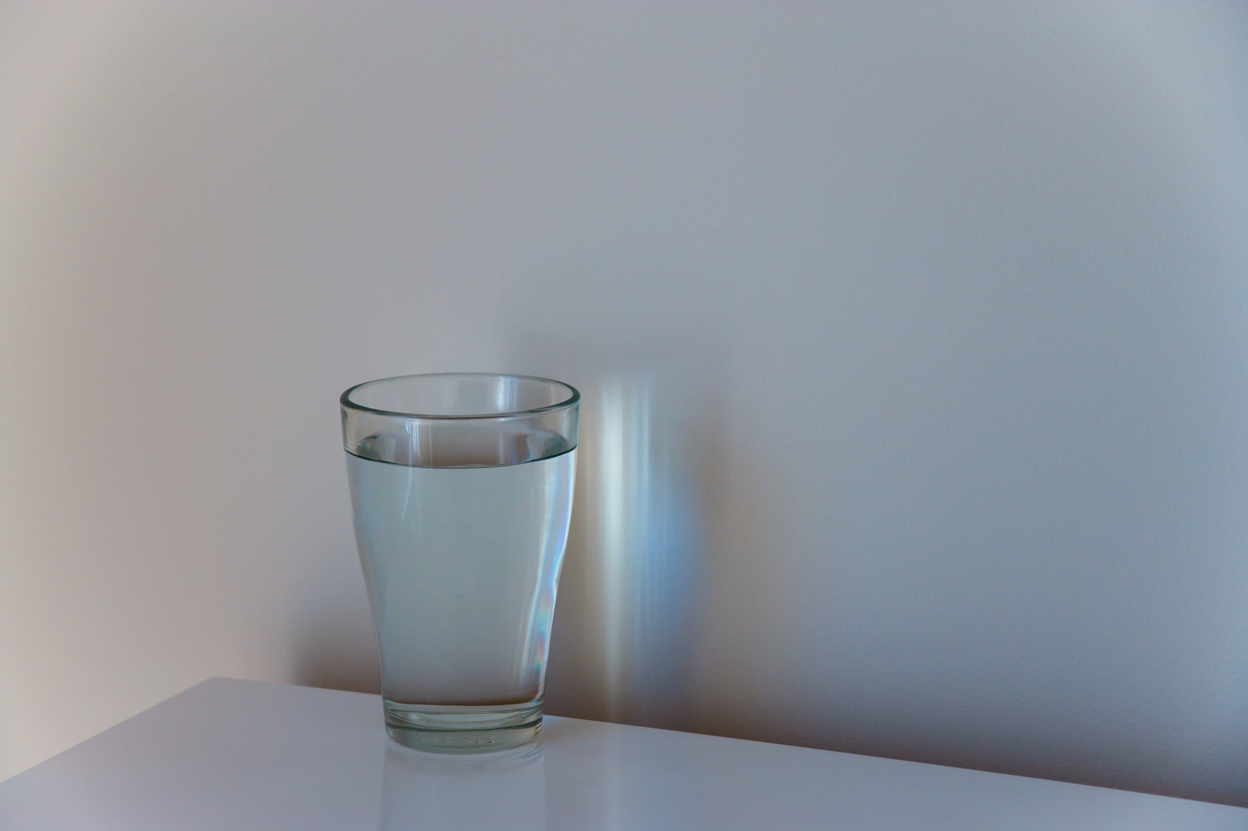 На столе стоят три склянки с водой. Стакан воды. Стакан воды на столе. Стакан воды Эстетика. Стакан на столе.