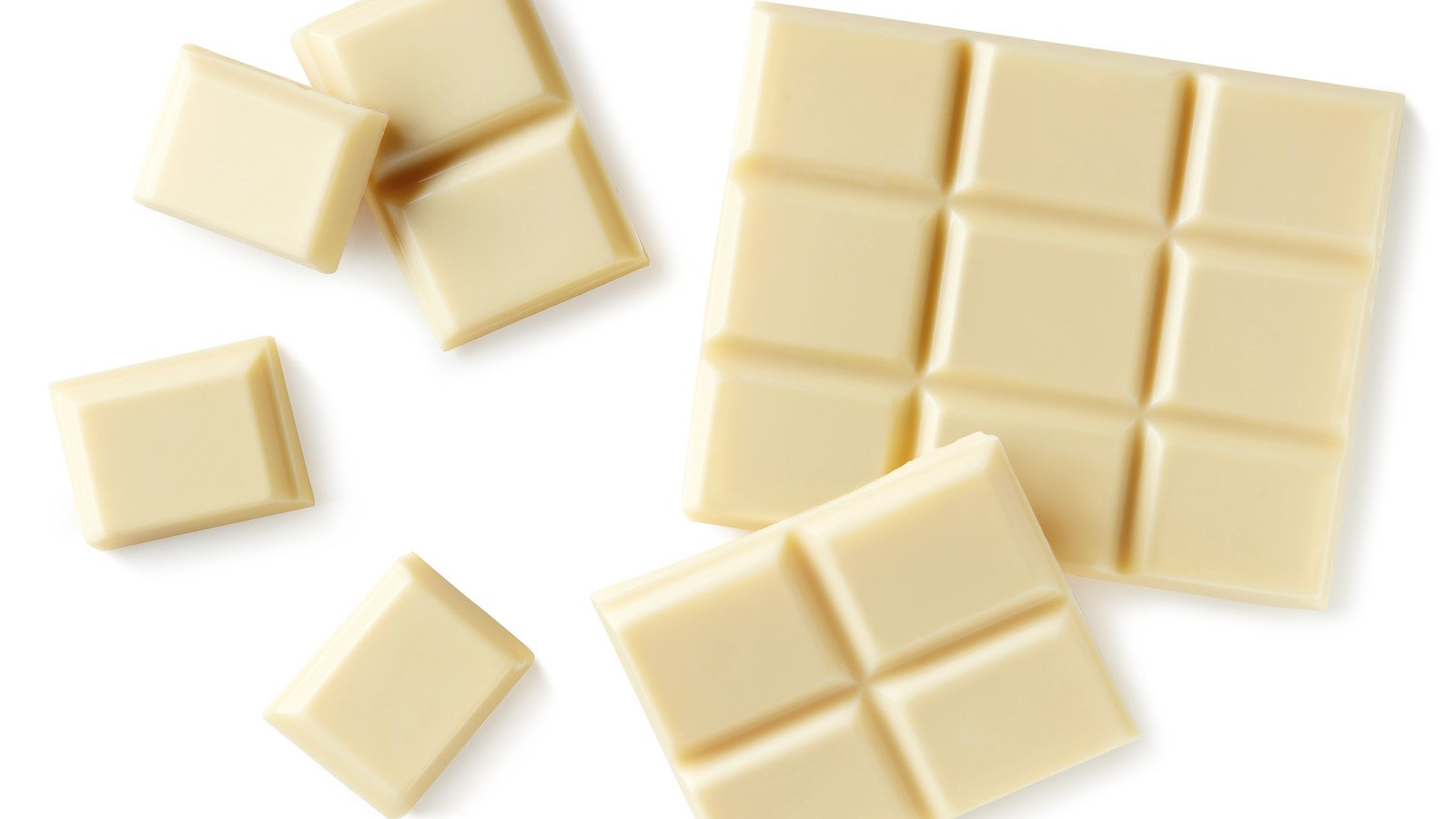 Кусочки белого шоколада. Белый шоколад. Кусочки шоколада на белом фоне. Белый шоколад вид сверху.