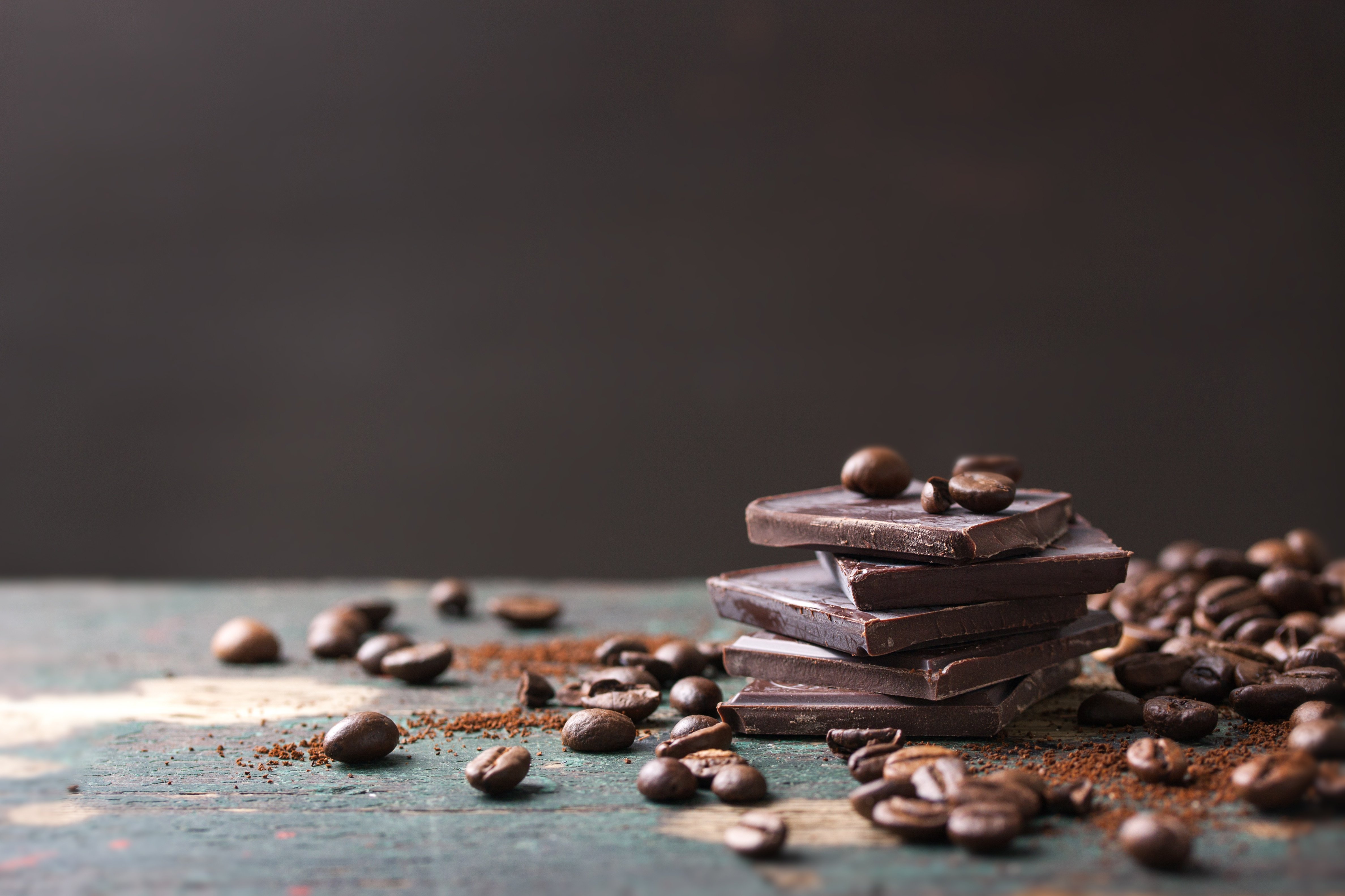 Шоколад столе. Шоколадный фон. Шоколад фон. Кофейные зерна. Фон темный шоколад.
